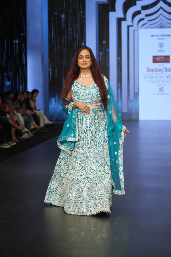 Model walking under stage lights during the grand finale